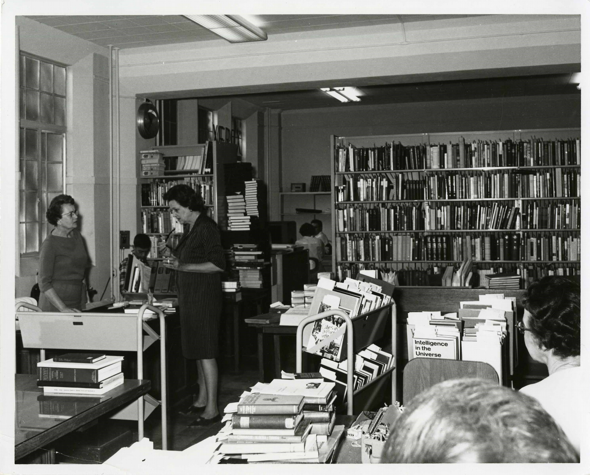 Black and white photo of people working in library office
